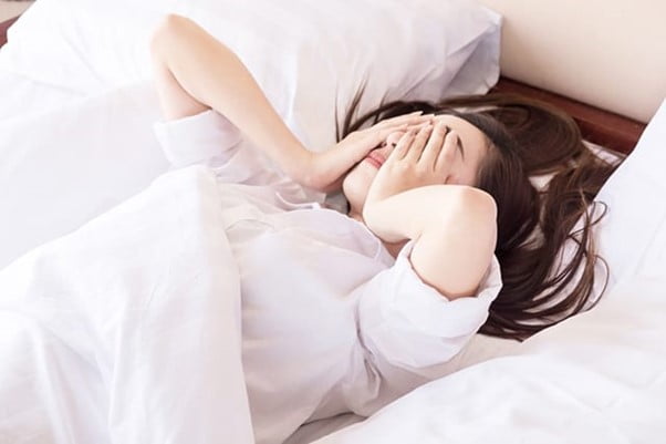 Woman waking up feeling tired.