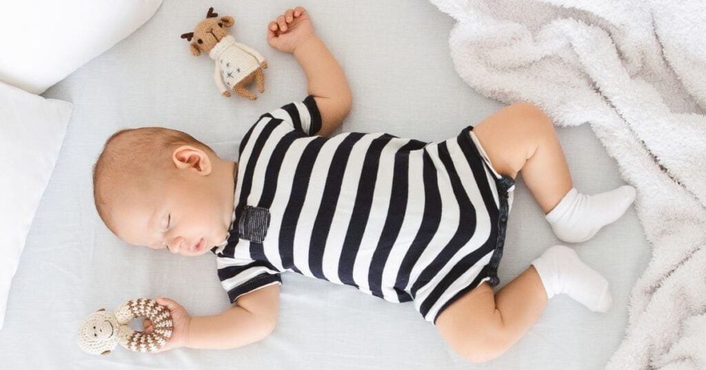 Baby sleeping on a baby cot mattress