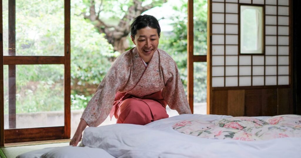 A Japanese woman making her futon bed.