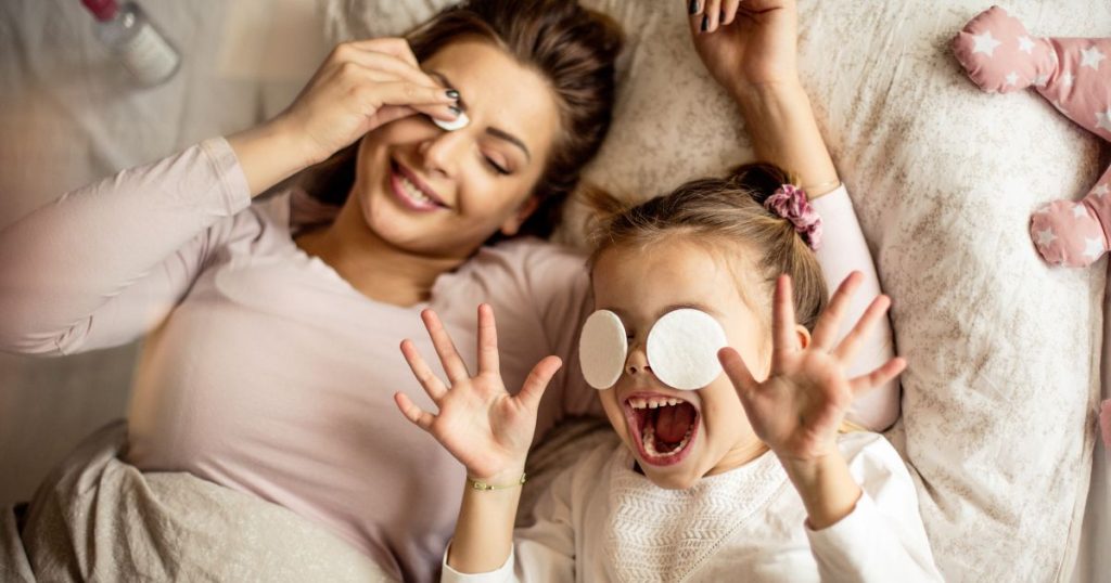 Mom and daughter giggling in bedroom before bed. 