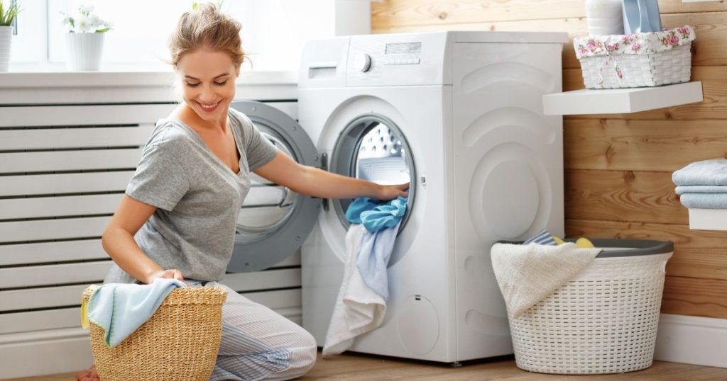 Woman using a washing machine to clean her pure wool duvet inner from Naturelle beds.