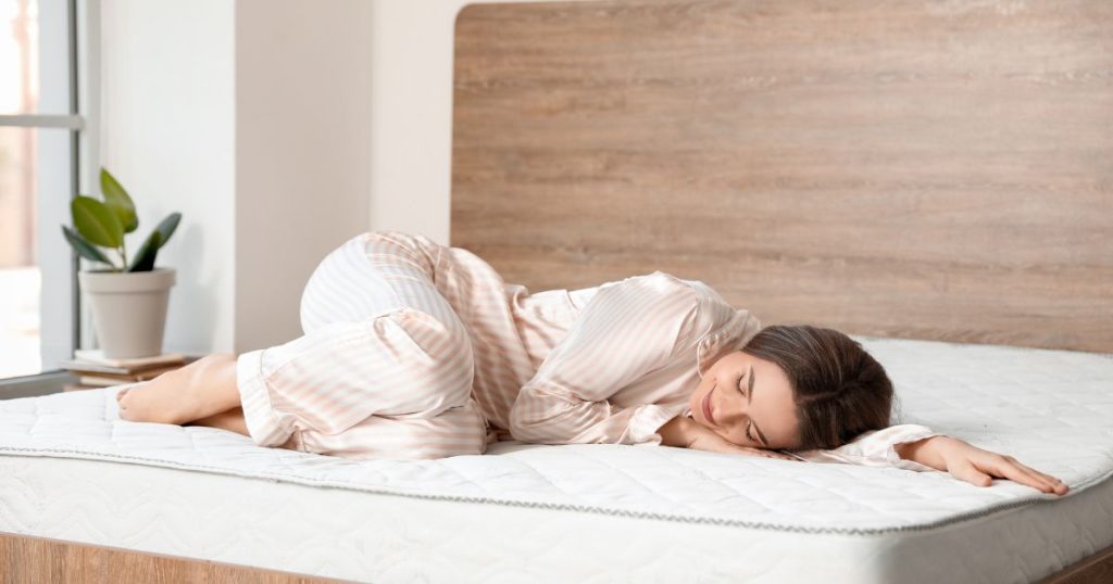 Woman smiling as she naps on a mattress made by Naturelle Beds.