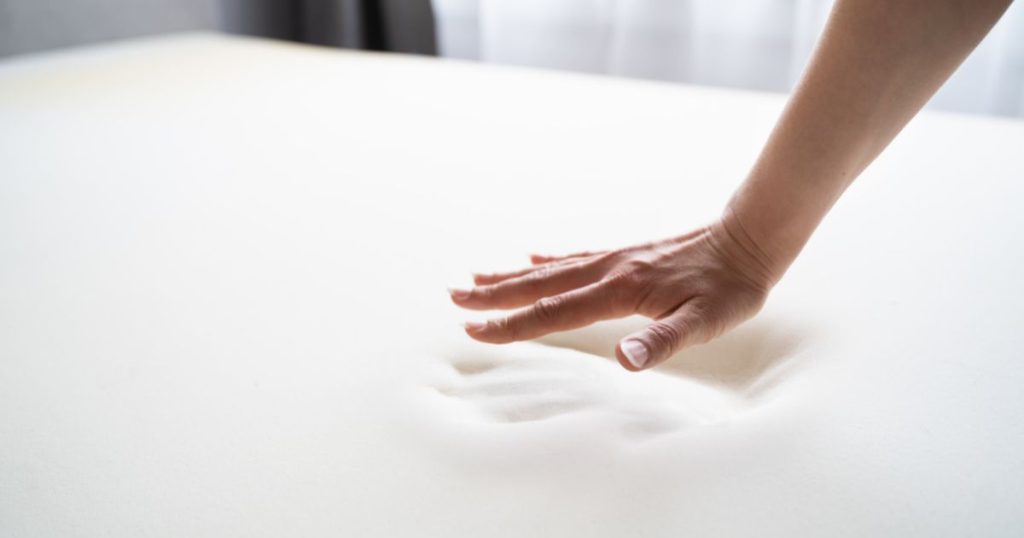 Hand pressing on memory foam to show how easily fibres become compressed.
