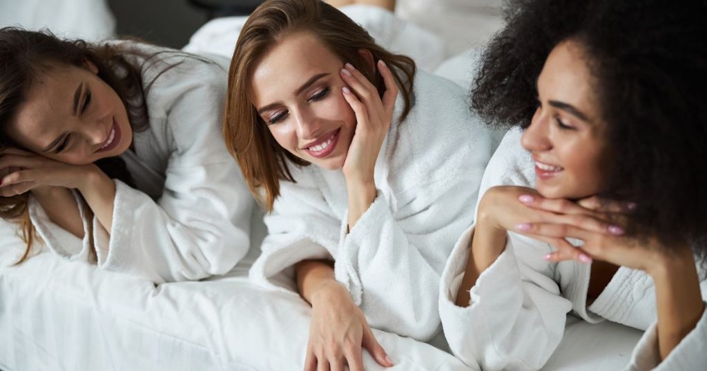 Three woman smiling as they lay next to eachother on the best mattress in South Africa.