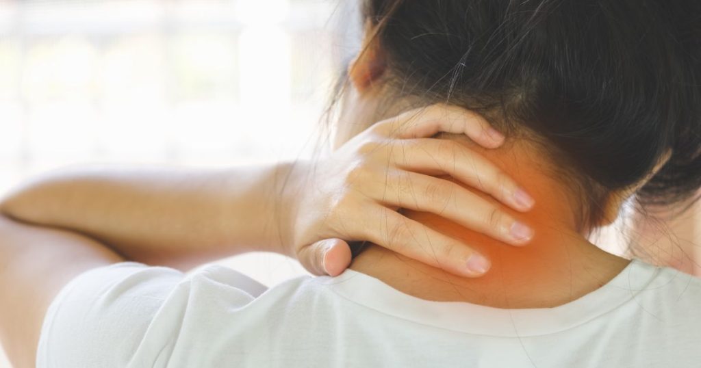 Woman with back pain holding her inflamed neck.
