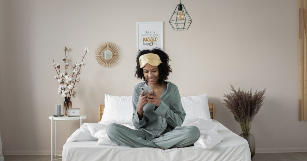 Young woman sitting on her bed before she goes to sleep