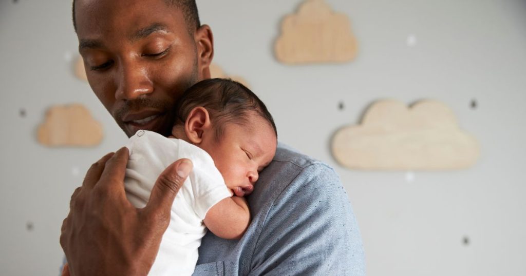 Man cradling his sleeping baby