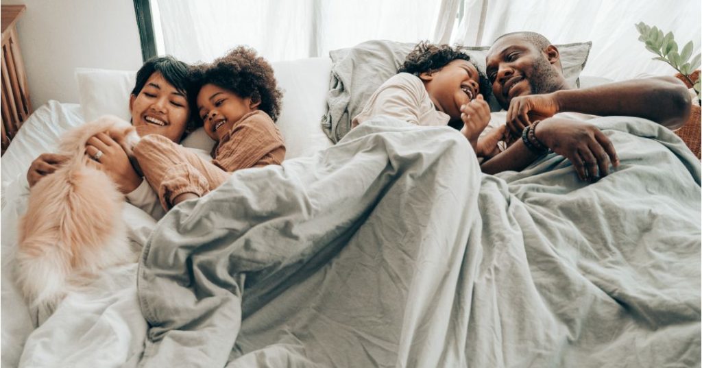 Family of four in a super king size bed
