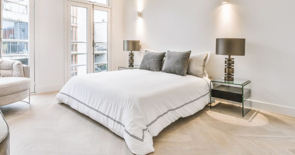 A super king size bed with grey and white bedding
