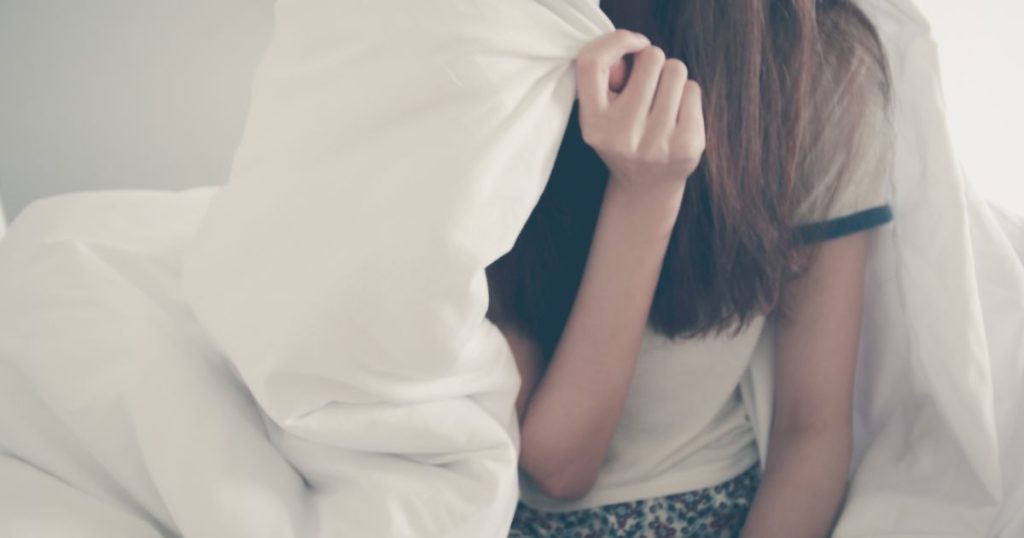 Woman holding a pure wool duvet ver her shoulders