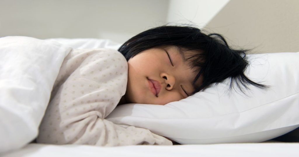 Young child sleeping on a white pillow