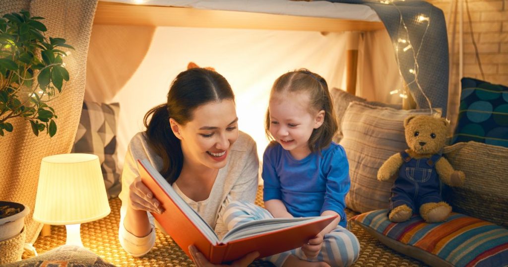 Mom reading to her daughter in bed