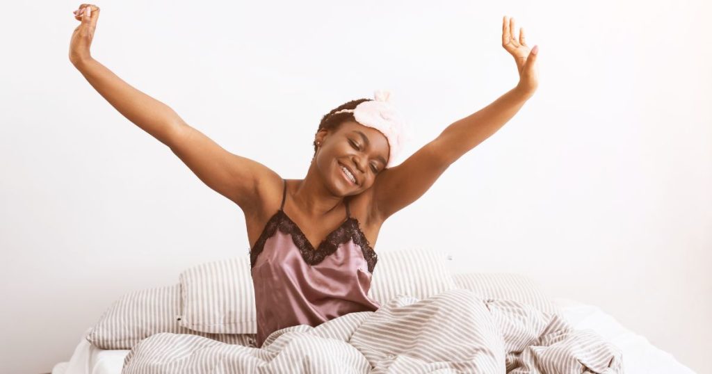 Happy woman waking up refreshed after a cool sleep